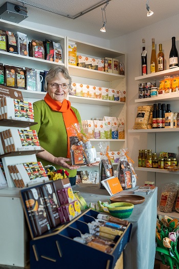 Edith Bruckwilder päsentiert ein Geschenkset an der Ladentheke im Eine Welt Laden Dinslaken