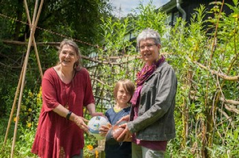 Lucie-Maria Rodemann und Sigrun Kampen übergeben Jannik Benning den Fairen Ball vom Netzwerk Faire Metropole Ruhr.