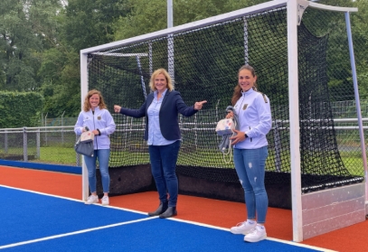 Bürgermeisterin Michaela Eislöffel steht mit beiden Olymioniken in einem Hockeytor