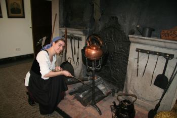 Museumspädagogin Cordula Hamelmann als Küchenmagd Marie an der historischen Herdstelle in der Küche des Voswinckelshofes